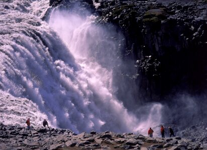 Tourist looking at the powerful waterfall of Dettifoss photo