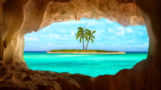 Viewing a tropical island and Palm tree through a cave photo