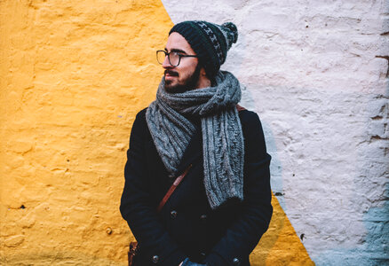 Young Male Wearing Coat, Hat and Scarf against Brick Wall photo