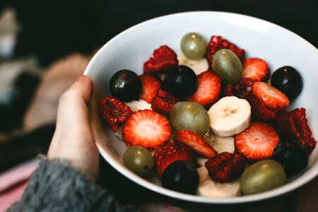 Hand holding a bowl of fruit photo