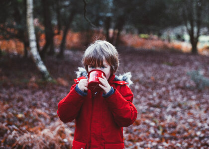 Little Cute Boy Drinks from a Metal Cup in the Autumn Park photo