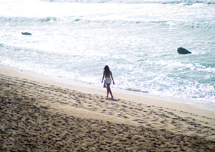 Young woman walk on an empty wild beach photo
