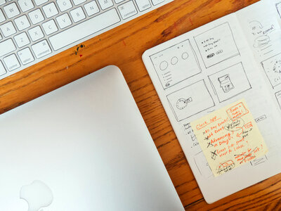 Wooden Desk with Keyboard, Laptop, and Sketchbook photo