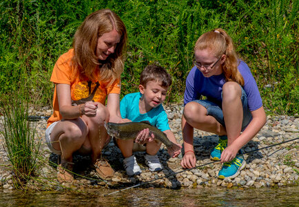 Family fishing, mother nets rainbow trout-2