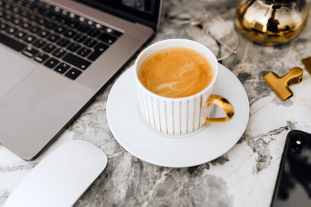 Coffee in a white cup on a marble desk photo