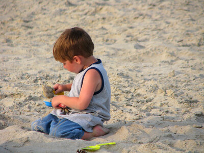 Young boy playing with his sand toys photo
