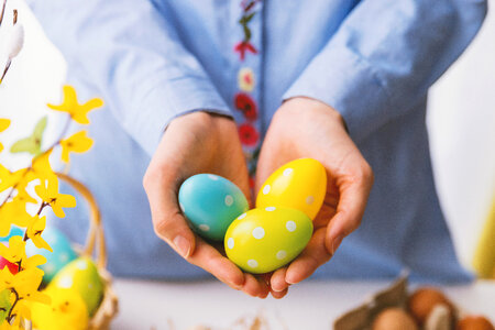 Hands holding modern painted easter eggs. photo