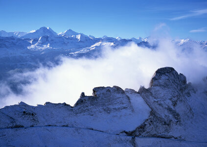 Snowy mountains in clouds photo