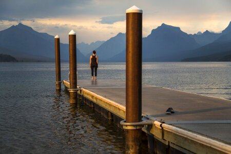 Women at the dock looking at Mountain Landscape at Glacier National Park, Montana photo