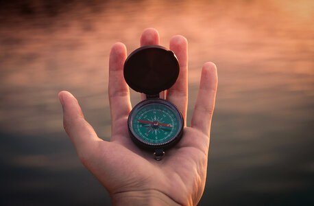 Human Hand with Compass against Blurred Background photo