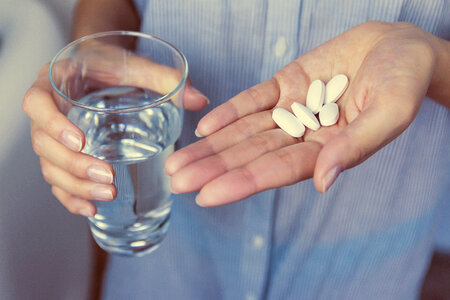 2 Hands of girl holding pills photo