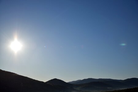 Clear Sky And Glaring Sun Over Hillside photo