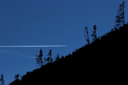 Contrail forest in the mountains sky photo