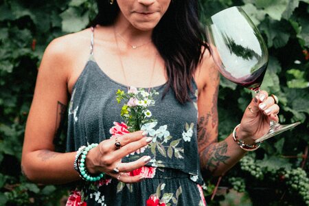 Women's Fashion Tattooed Woman Holding Flowers And Wine photo