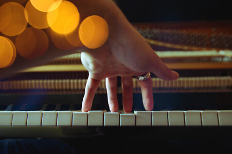 Close Up of Left Hand of a Young Woman Playing Piano photo