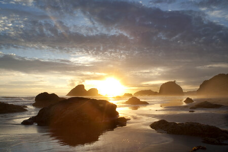 Sunlight setting behind coastal rocks photo