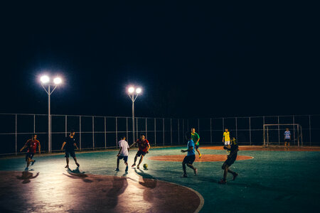 People playing soccer under the streetlamps photo