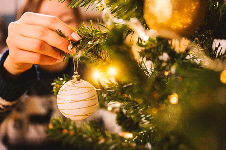 2 Woman decorating Christmas tree with baubles photo