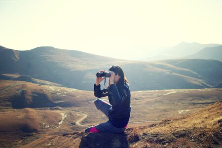 Girl Looking through Binoculars in the Mountains photo