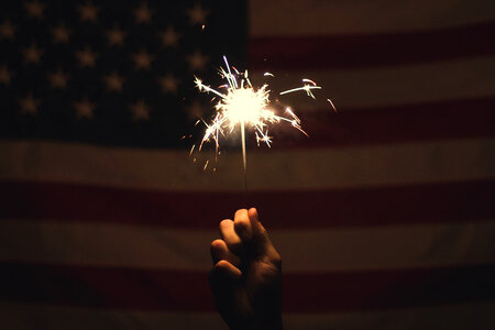 Fireworks in Hand, USA Flag on Background photo