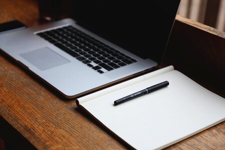 Laptop, Notepad & Pen on Desk photo