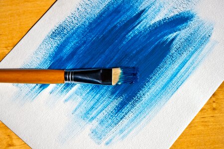 Brush painting blue paint on white background photo