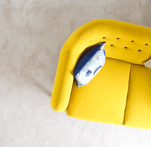 Yellow Sofa with Pillow on Beige Carpet Background photo