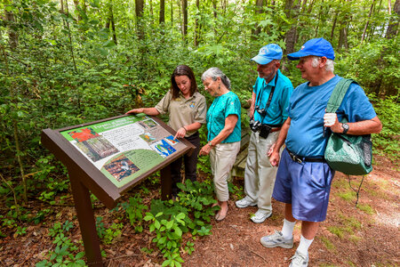 FWS Visitor services staffer shows interpretive panel to visitors-2 photo