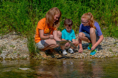 Family fishing, mother nets rainbow trout-2