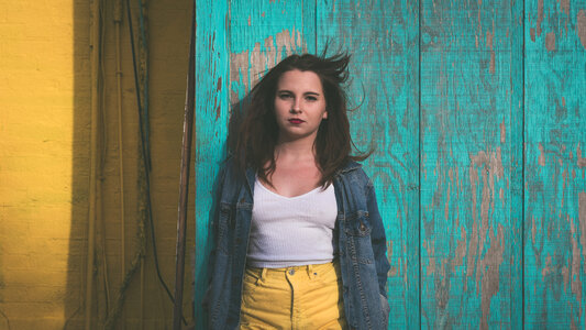 Young Woman Standing against Wooden Turquoise Wall photo
