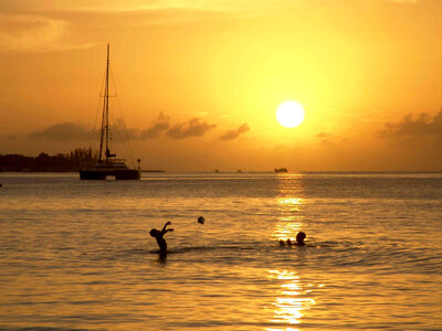 Sunset over the ocean with two people playing in Jamaica photo