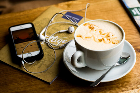 iPhone with the EarPods and Coffee on a Wooden Table photo