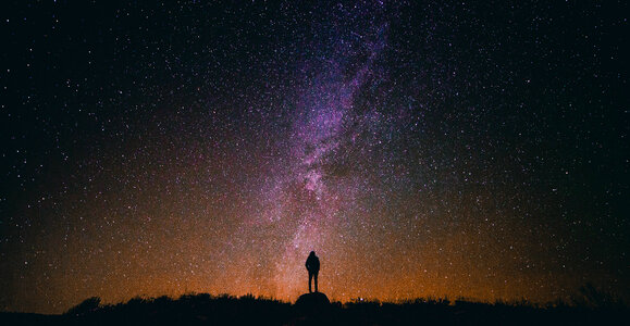 Person standing under the Milky Way photo