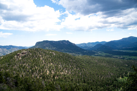 Clouds above the trees and mountains photo