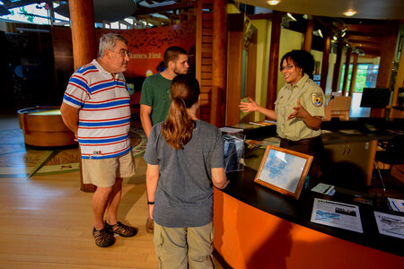 FWS Staff greets visitors at visitor center desk photo