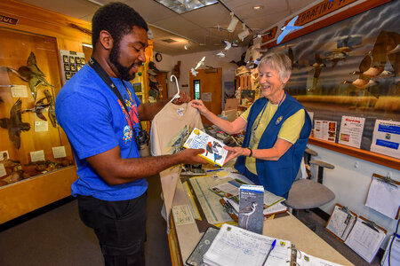 FWS volunteer with visitor in gift shop