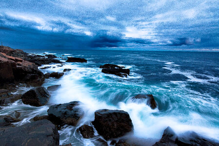 Waves of the ocean crashing on shore with skies in Acadia National Park