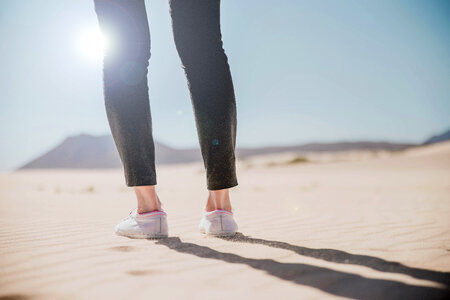 Back view of legs standing at desert