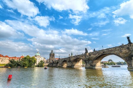 2 Beautiful day with blue sky and clouds in Prague and a view of the bridge from the river photo