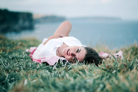 Joyful Young Woman Lies on the Grass photo