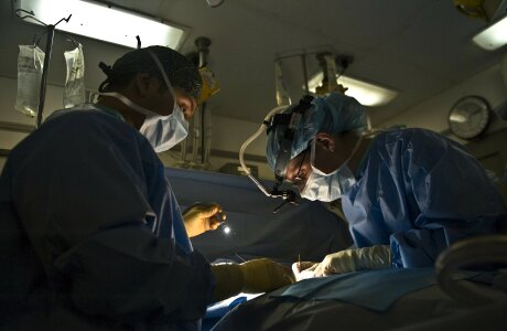 Surgeons surrounding patient on operation table photo