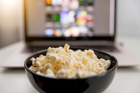 Watching movies online on laptop and eat popcorn. photo