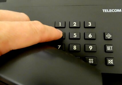 One human finger pressing key on phone photo