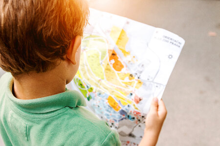Small boy looking in to the map at amusement park photo