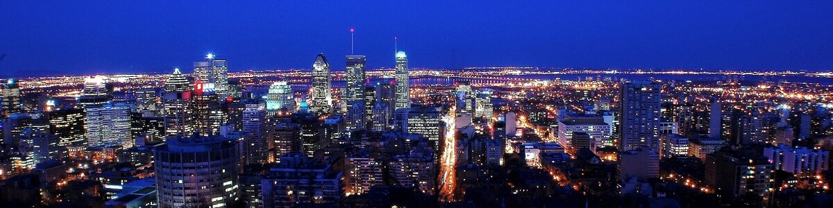 Montreal over river at sunset with city lights and urban building