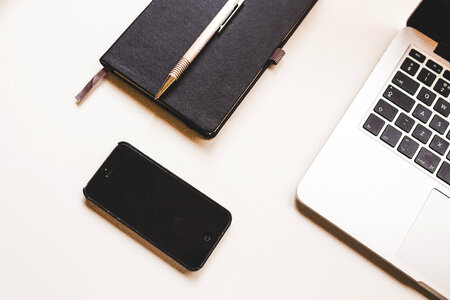Black iPhone, MacBook & Notepad photo