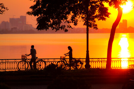Sunset and 2 cyclists in Hanoi, Vietnam photo