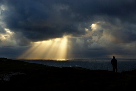 A man on a silhouetted against the sun's rays