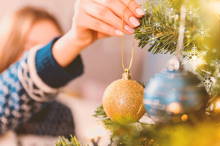 1 Woman decorating Christmas tree with baubles photo