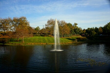 Beautiful pond in the autumn with a fountain spraying photo